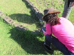Ximena Catepillan examining the foundation of a Rapa Nui boat house.